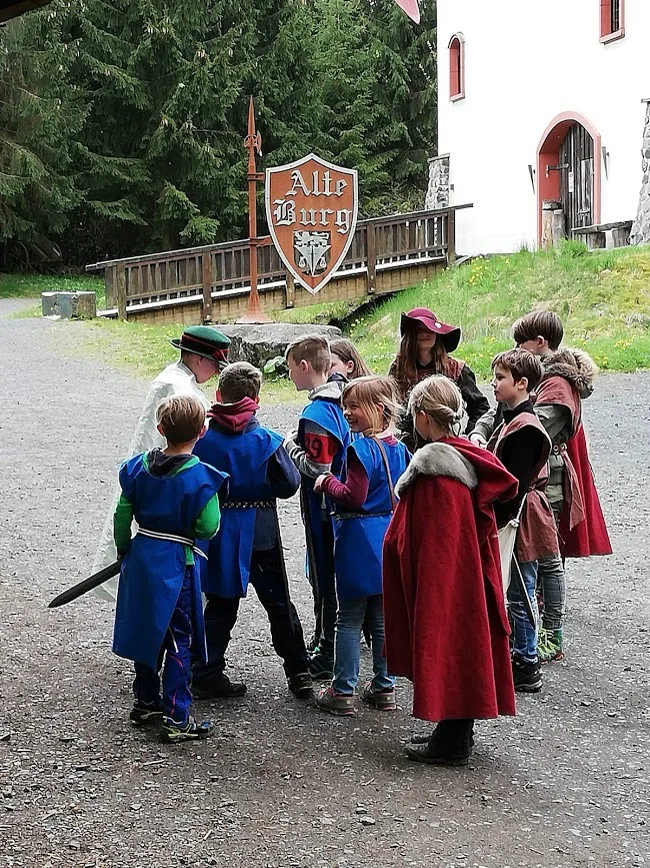 Eine Waldritter-Gruppe in Gewandung vor der Alten Burg